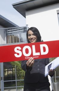 Real Estate Agent Holding Sold Sign